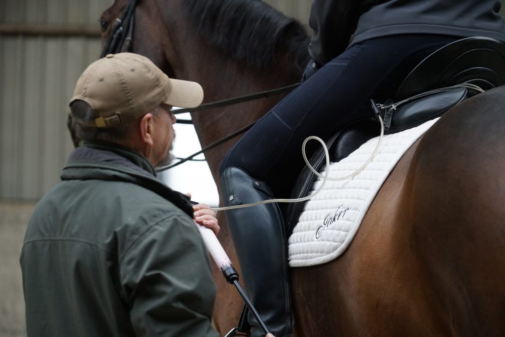Kerry past de hoeveelheid lucht aan terwijl de ruiter op het paard zit.